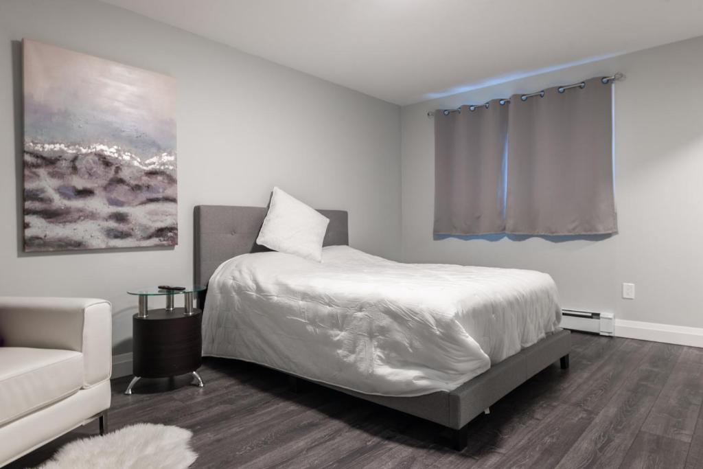 a white bedroom with a bed and a couch at PRIVATE ROOM ENSUITE UPTOWN WATERLOO - e5 in Waterloo