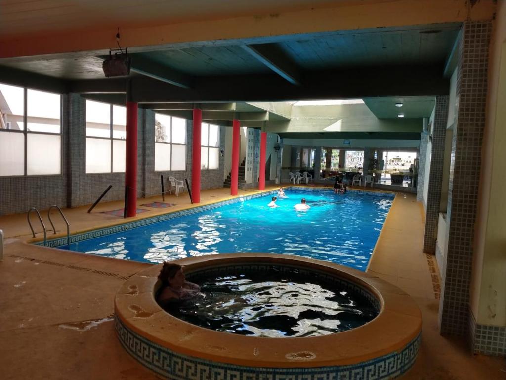 - une grande piscine avec un chien dans l'eau dans l'établissement San Remo World Hotel, à San Clemente del Tuyú