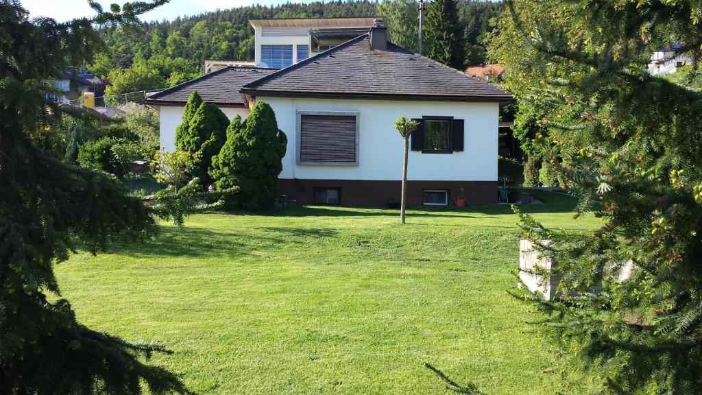 a house in a yard with a green lawn at Bungalow Möwe in Pörtschach am Wörthersee