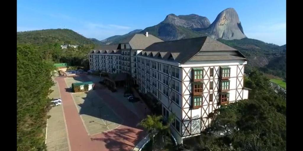 an aerial view of a building with mountains in the background at Vista Azul Suites in Pedra Azul