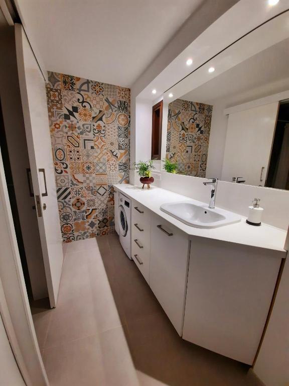 bagno con lavandino e lavatrice di BELLE VUE Mountain Home a Kalopanayiotis