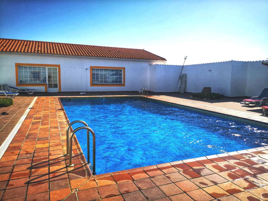 a swimming pool in front of a house at Varandas de Alter Hotel & SPA in Alter do Chão