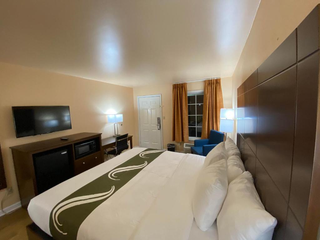 um quarto de hotel com uma cama grande e uma televisão em Quality Inn em Pulaski
