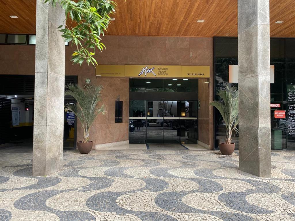 a lobby with potted plants in front of a building at Condomínio Max Savassi Superior apto 1502 in Belo Horizonte