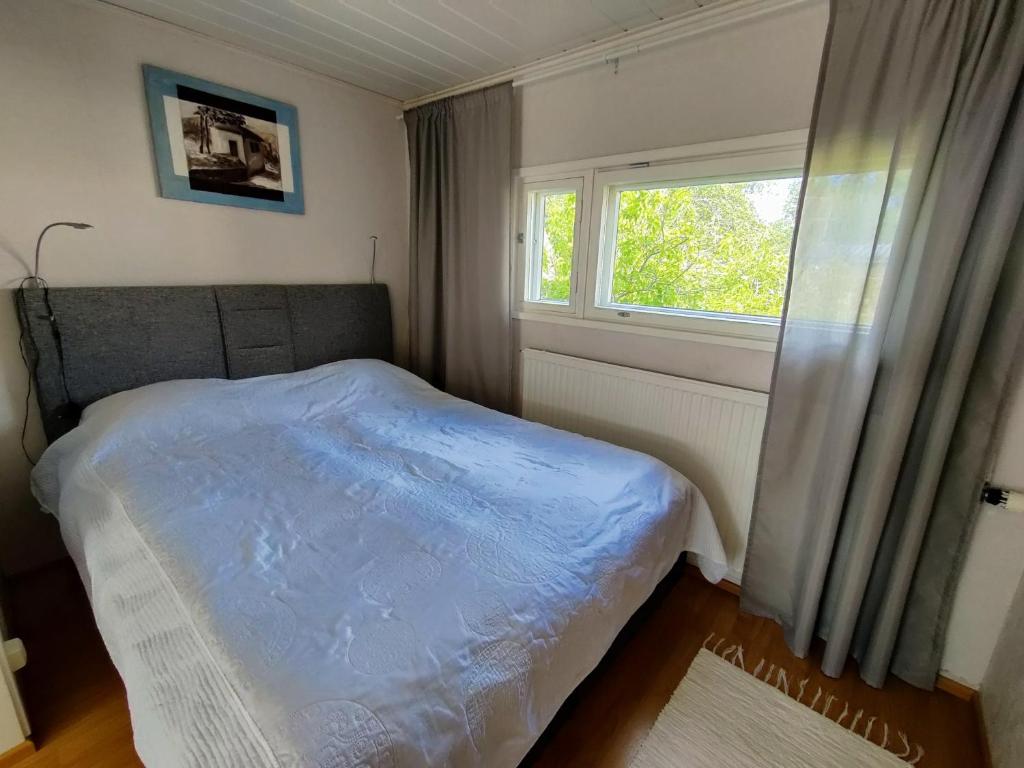 a small bedroom with a bed and a window at Polku Apartaments in Imatra