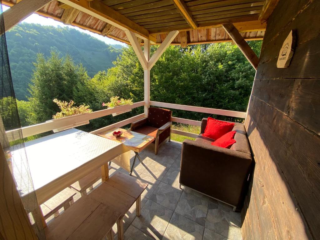 eine abgeschirmte Veranda mit einem Tisch und Stühlen in der Unterkunft Turizam Raković in Ivanjica