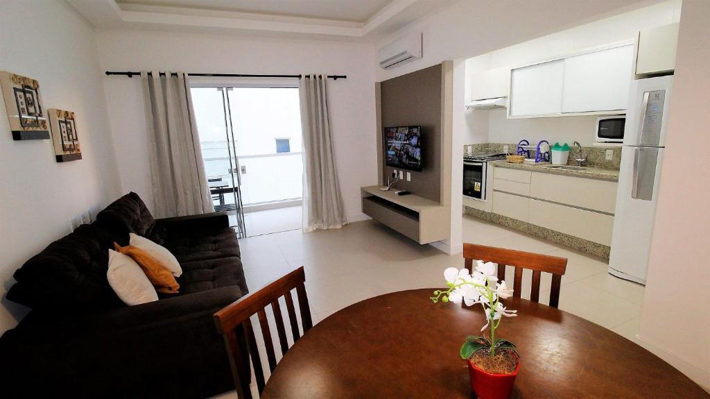 sala de estar con sofá negro y mesa en 1069 - Praia de Bombinhas locação de temporada, en Bombinhas