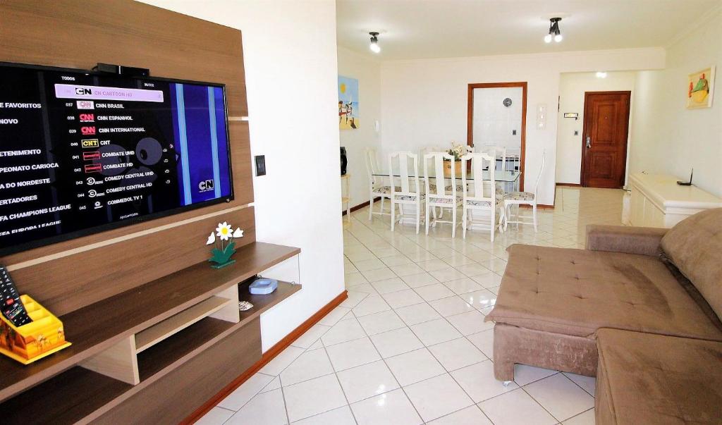sala de estar con sofá y TV de pantalla plana en 1038 - Apartamento com vista para o mar na Avenida De Bombinhas, en Bombinhas