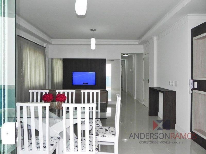 Sala de estar con 2 sillas blancas y TV en 1058 - Praia de Bombinhas locação de temporada, en Bombinhas