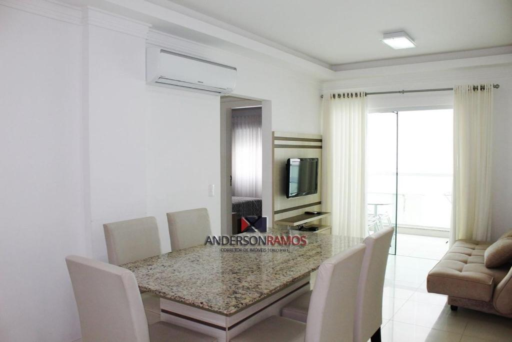 comedor con mesa de cristal y sillas en 1040 - Apartamento para locação em Bombinhas - Residencial Egídio Pinheiro Apto 206 A, en Bombinhas