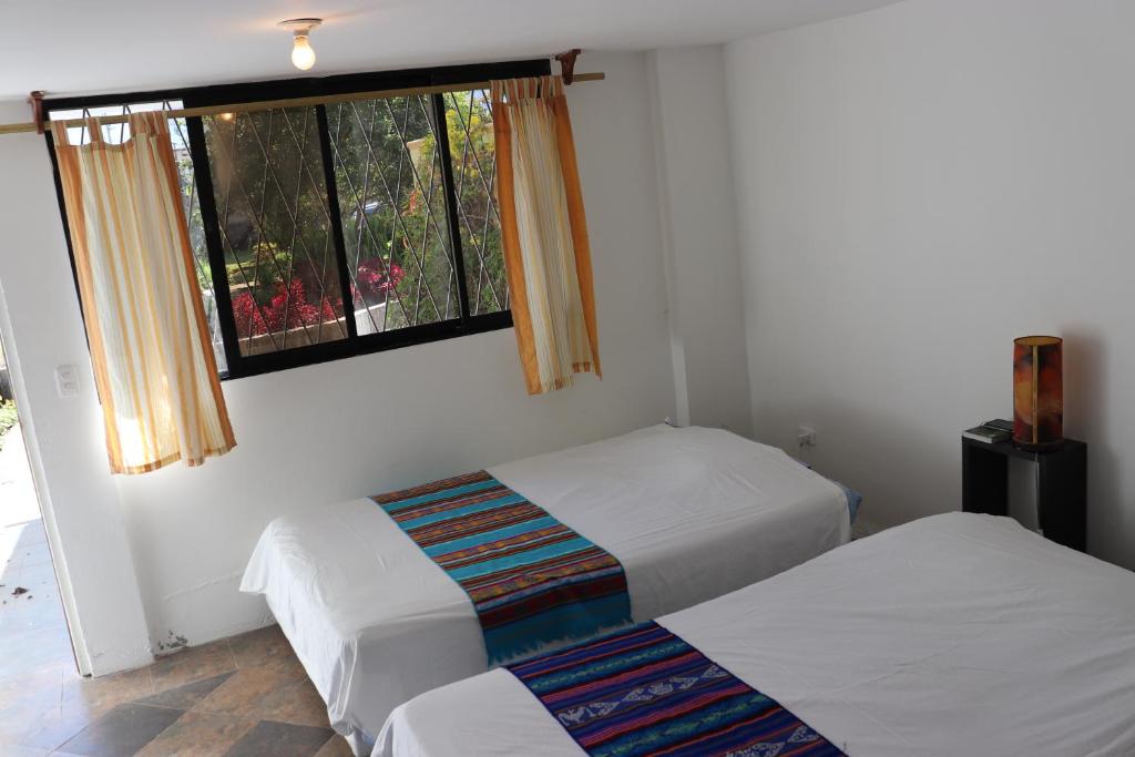 2 camas en una habitación con ventana en DEPARTAMENTO PRIVADO EN QUINTA x 6 PERSONAS Jardines y Naturaleza, en Baños