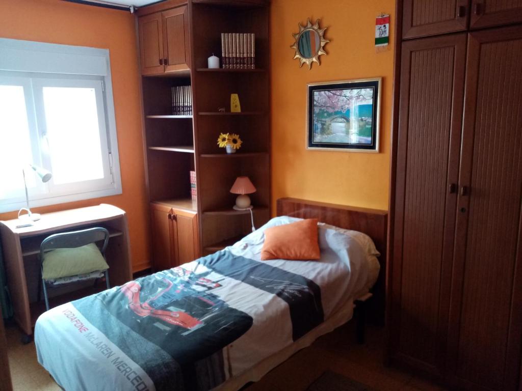 a bedroom with a bed and a desk and a window at Habitación silenciosa cerca del Hospital valdecilla in Santander