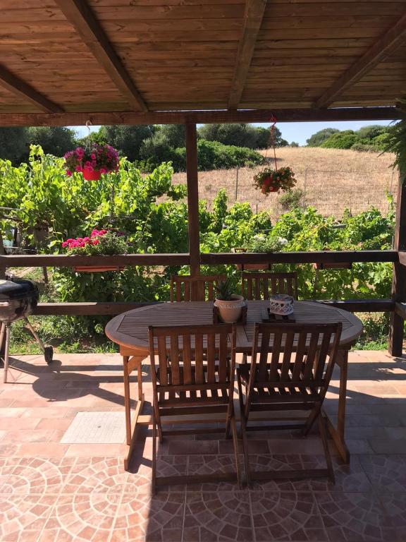 een houten tafel en stoelen op een terras bij Casa Vittoria in Palau