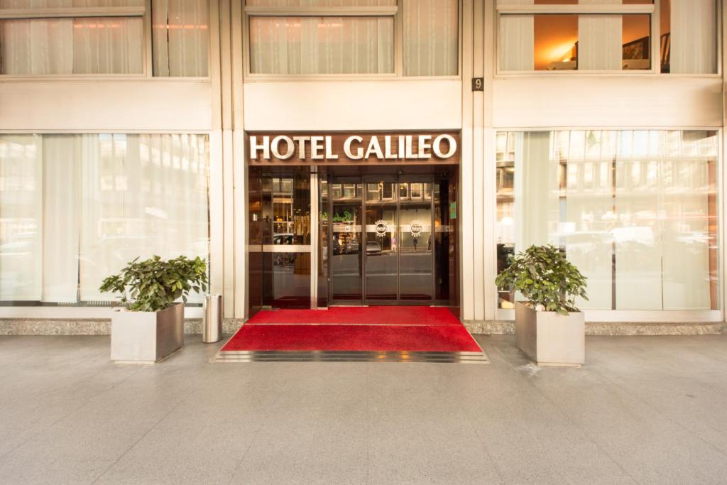 a hotel lobby with a red rug in front of a building at Hotel Galileo in Milan