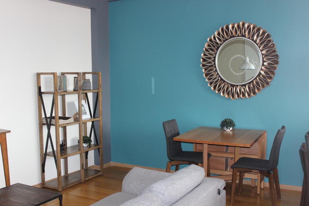 uma sala de estar com uma mesa e um espelho numa parede azul em Downtown Mexico City, full apartment em Cidade do México