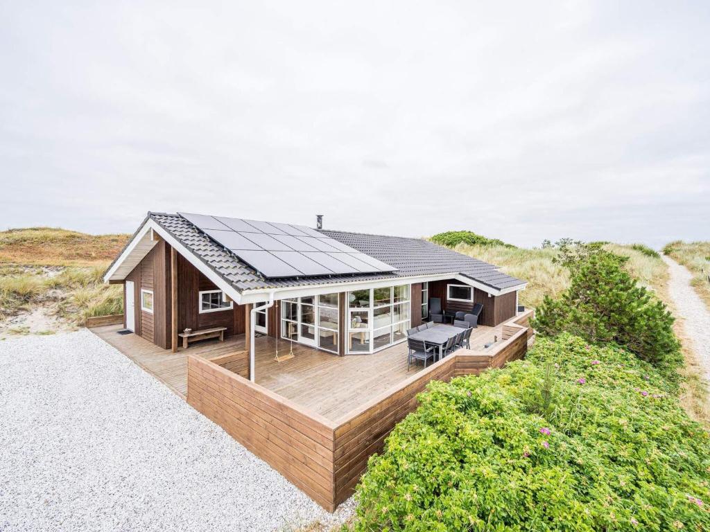 uma casa com telhado solar numa praia em Holiday home Hvide Sande XLV em Bjerregård