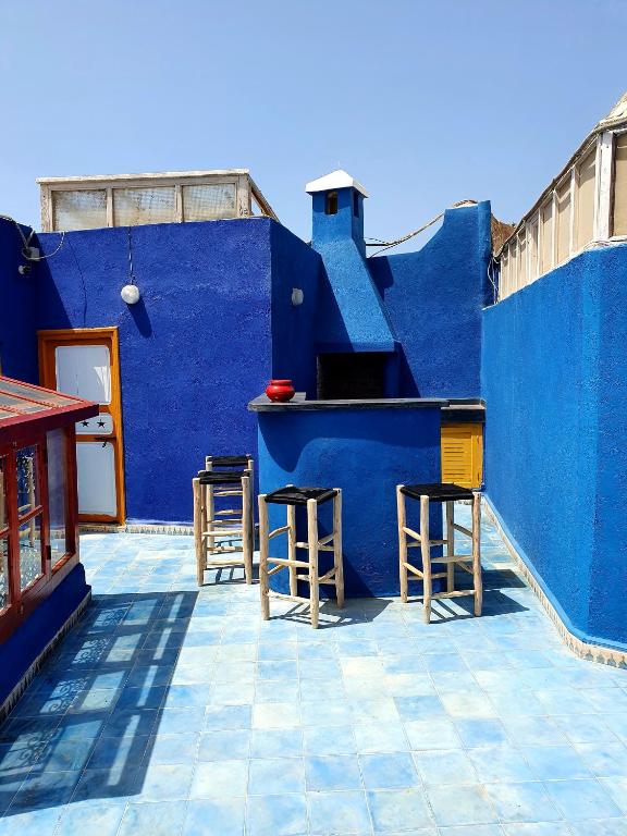 a blue building with a bar and stools at Dar Massaneh in Essaouira