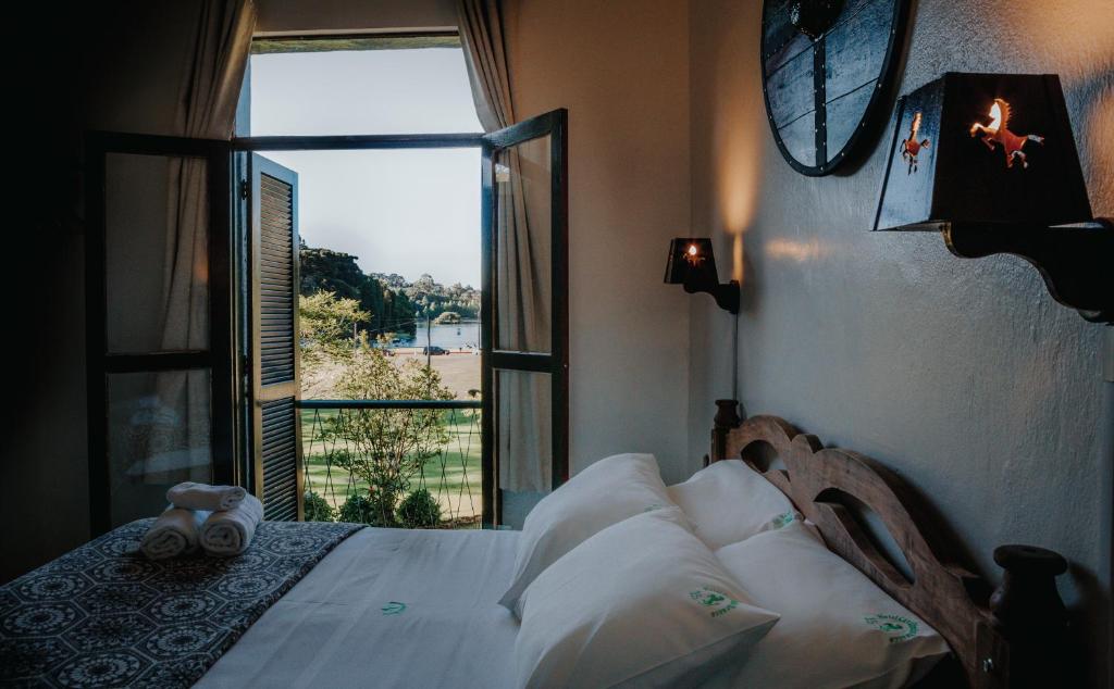 a bedroom with a bed and a large window at Hotel Cavalinho Branco in São Francisco de Paula