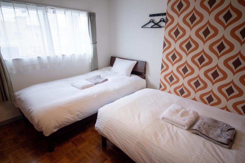Postel nebo postele na pokoji v ubytování tune Hostel（ツネホステル館山）