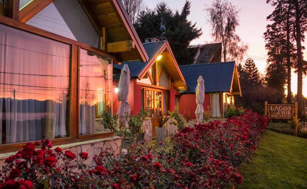 a house with flowers in front of a building at Lagos del Sur in San Carlos de Bariloche