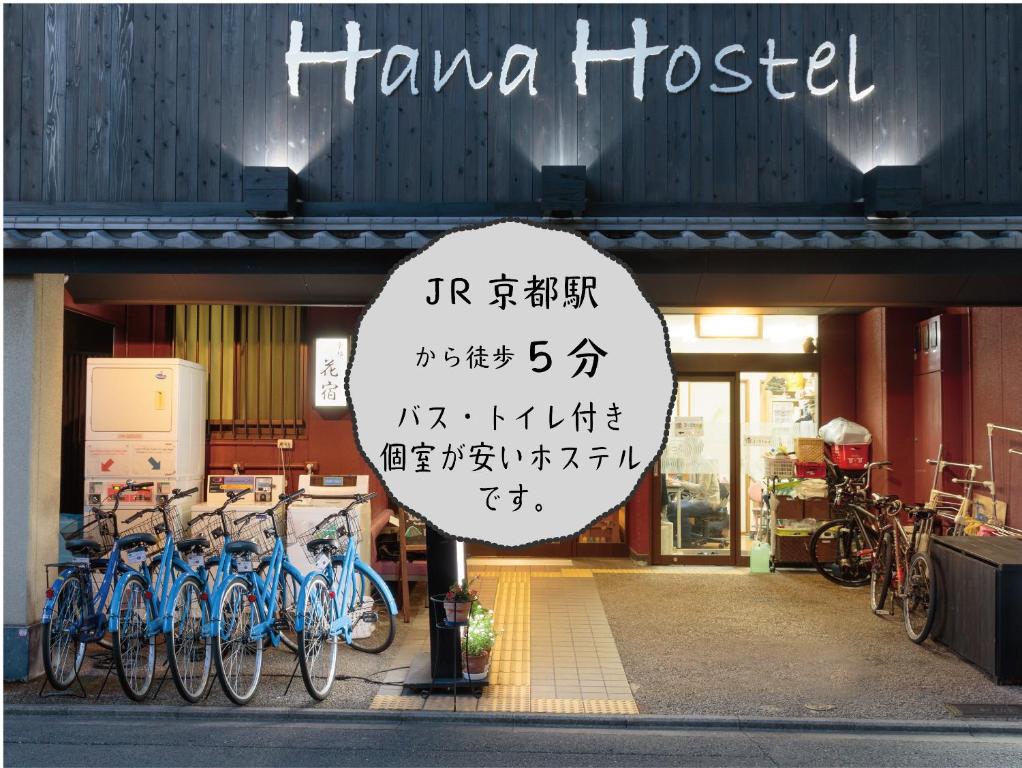 a sign in front of a store with bikes parked outside at Kyoto Hana Hostel in Kyoto