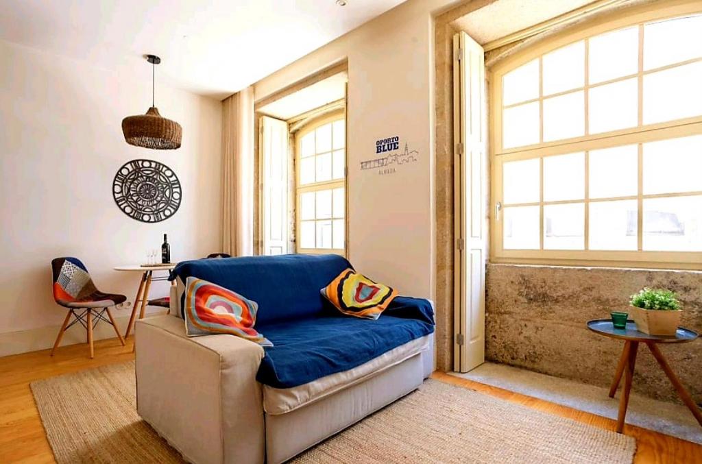 - un salon avec un canapé et une table dans l'établissement Oporto Blue Almada - Deluxe Citycenter Flat, à Porto