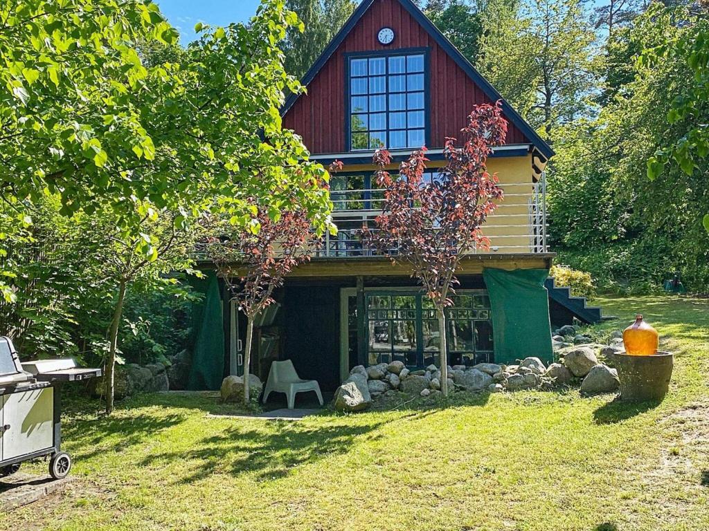 Cabaña de madera con techo rojo y árbol en 4 person holiday home in KIVIK, en Kivik