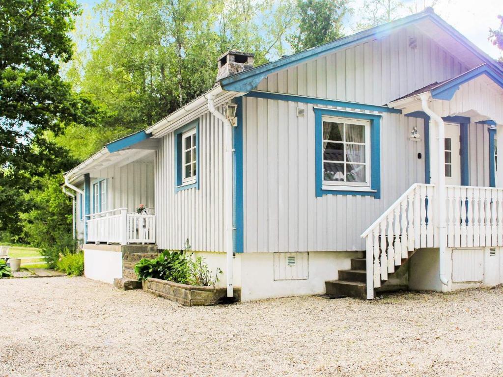 een wit en blauw huis met een veranda en een trap bij 6 person holiday home in TROLLH TTAN in Trollhättan