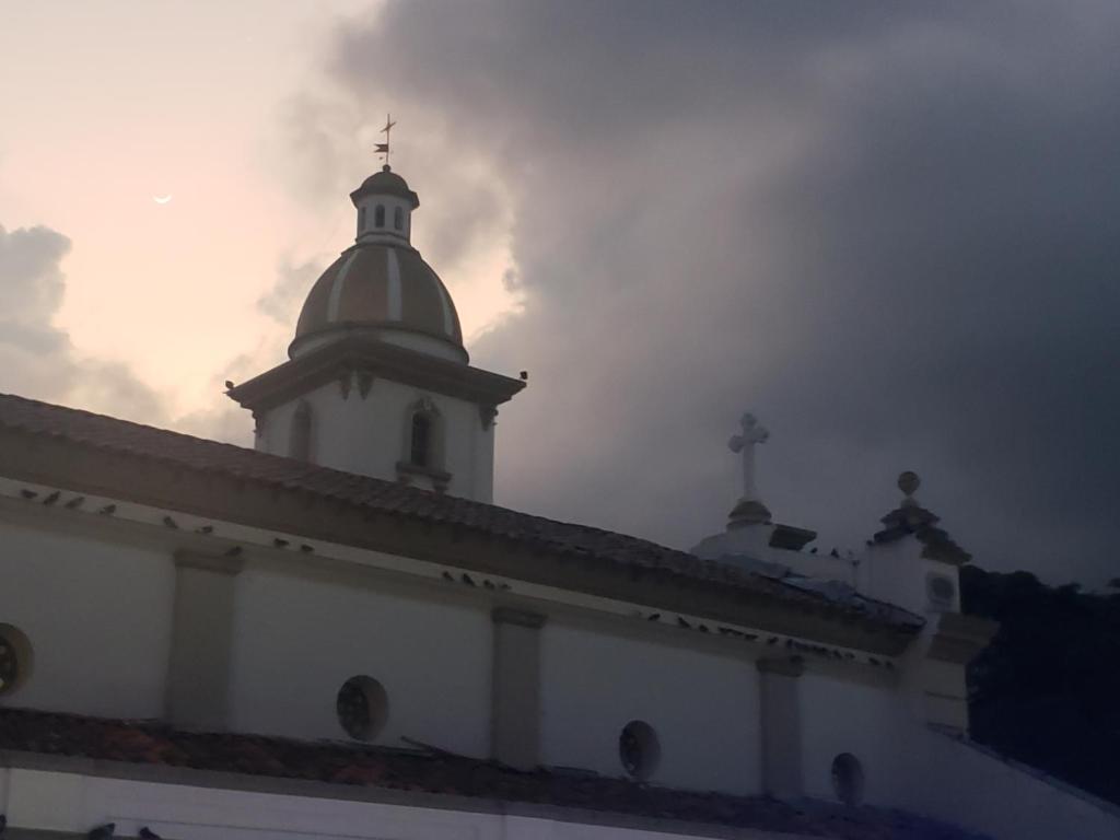 a white building with a cross on top of it at Aima Ibagué in Ibagué