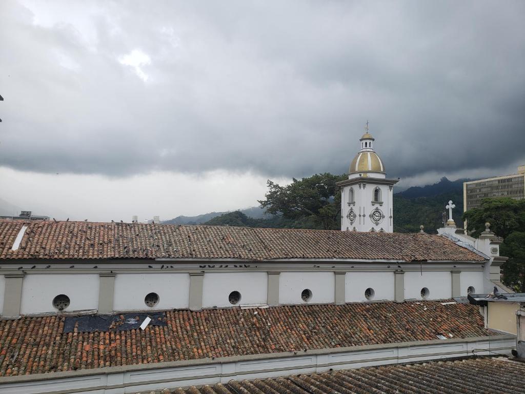 a white building with a clock tower on top of a roof at Aima Ibagué in Ibagué