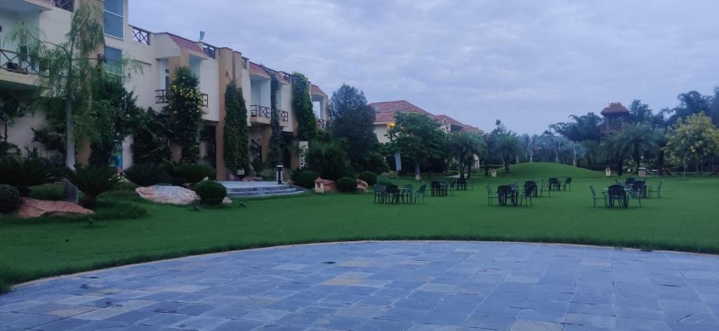 a courtyard with tables and chairs in a park at Resort De Coracao - Corbett , Uttarakhand in Rāmnagar