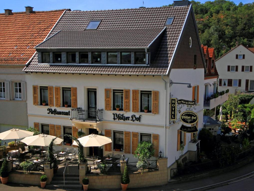 a hotel with tables and umbrellas in front of it at Hotel Pfälzer Hof in Lauterecken