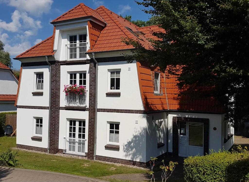 una casa blanca con techo naranja en Ferienwohnung Bernsteinsucher städtische Bestlage en Ribnitz-Damgarten