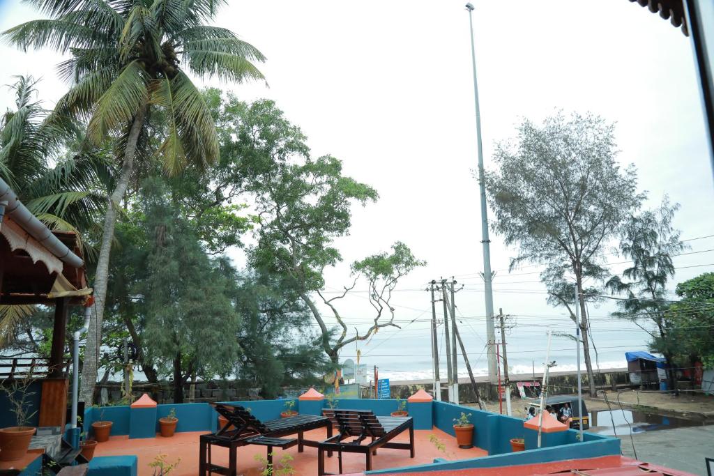 two benches sitting on a table in a park at Sajeev Home Stay in Cherai Beach