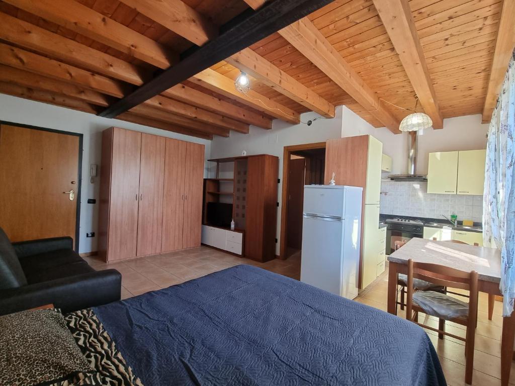 sala de estar con cama y cocina en ANTICA CORTE ORTAIA APPARTAMENTI, en Povegliano Veronese