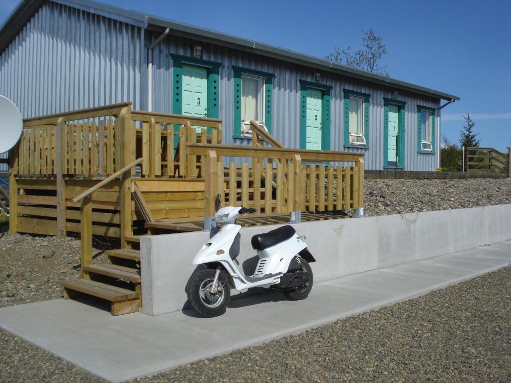 un pequeño scooter blanco estacionado frente a un edificio en Vinland Guesthouse, en Egilsstadir