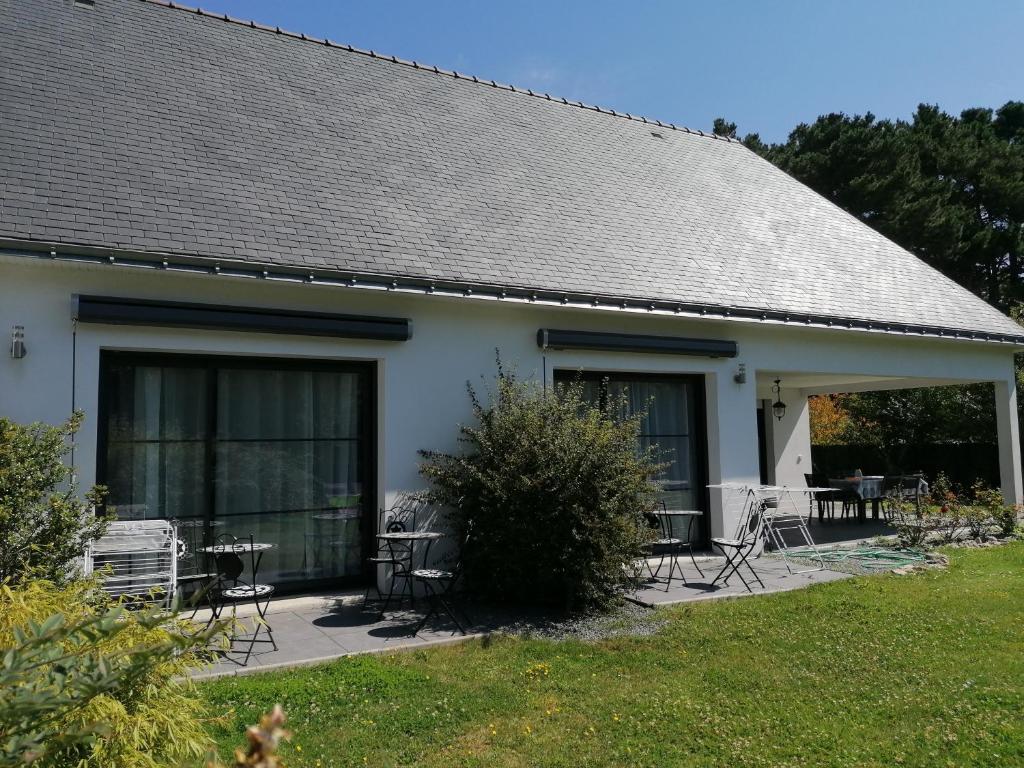 a white house with chairs and a patio at Chambres d&#39;hotes Grace in Guérande