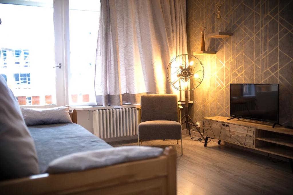 - un salon avec un canapé et une télévision dans l'établissement Le Rosset, à Tignes
