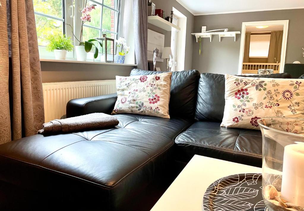 a black leather couch in a living room at Beachhouse Schwedeneck in Surendorf