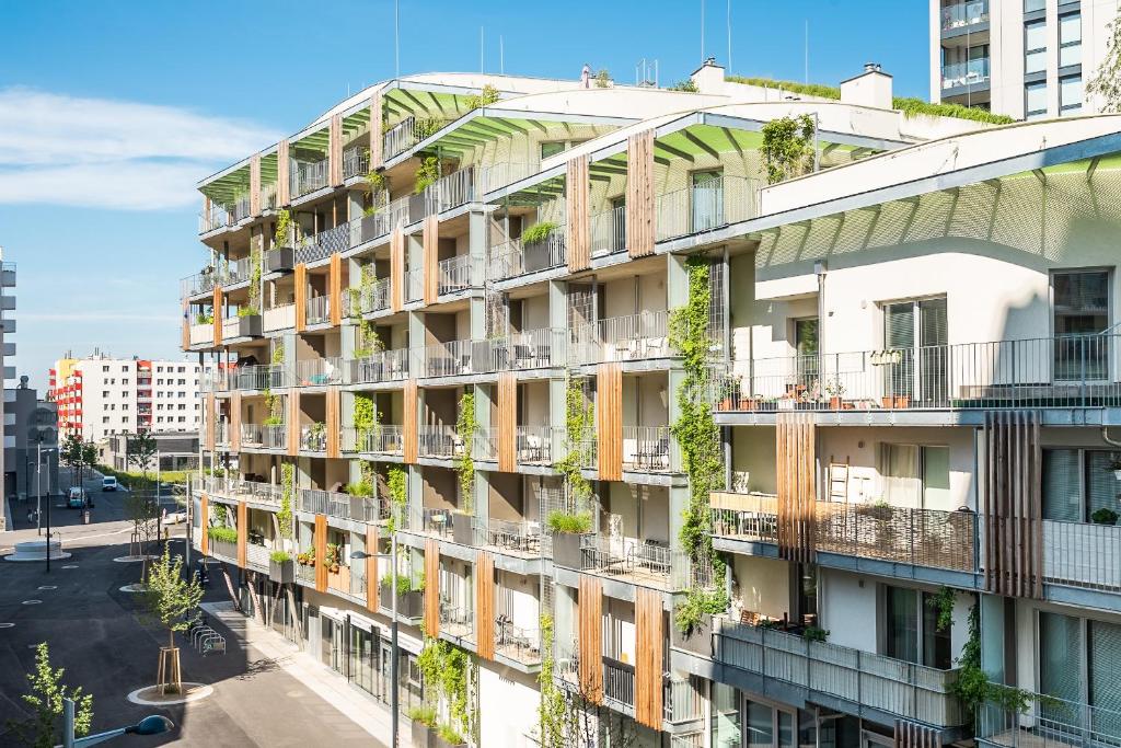 an apartment building with balconies and plants at FeelGood Apartments GreenLiving | contactless check-in in Vienna