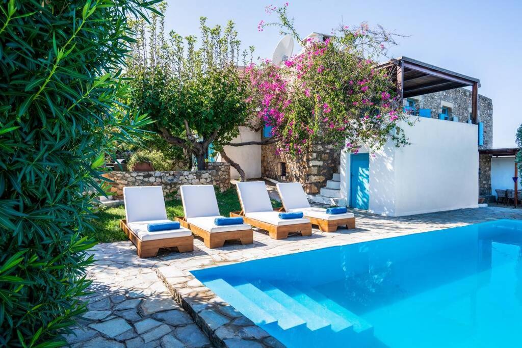 a group of chairs next to a swimming pool at A 3bedroom country house, with pool close to beach in Roumelí