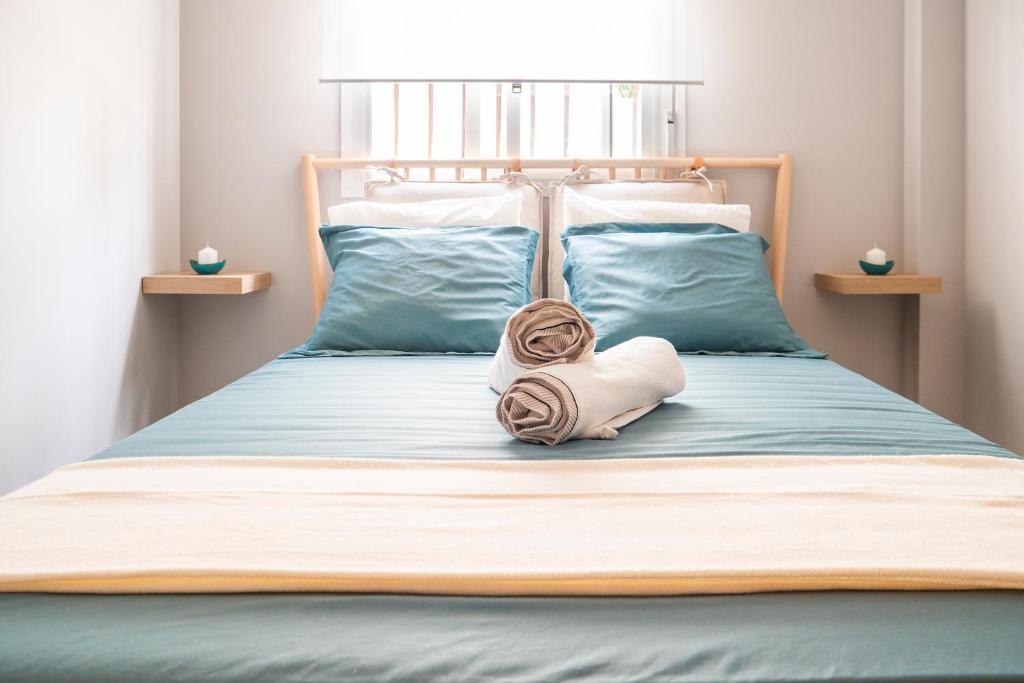 Una cama con cabecero y una toalla. en Apartamento AGUASAL, en Sanlúcar de Barrameda