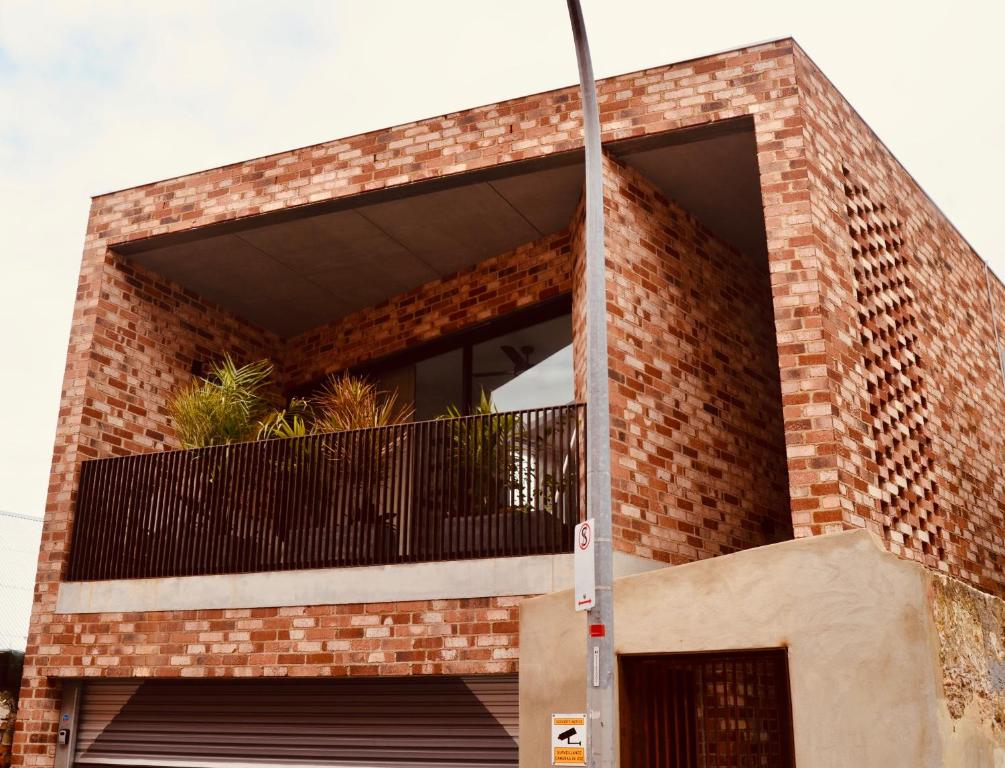 - un bâtiment en briques avec un balcon au-dessus dans l'établissement Angels Loft Fremantle, à Fremantle