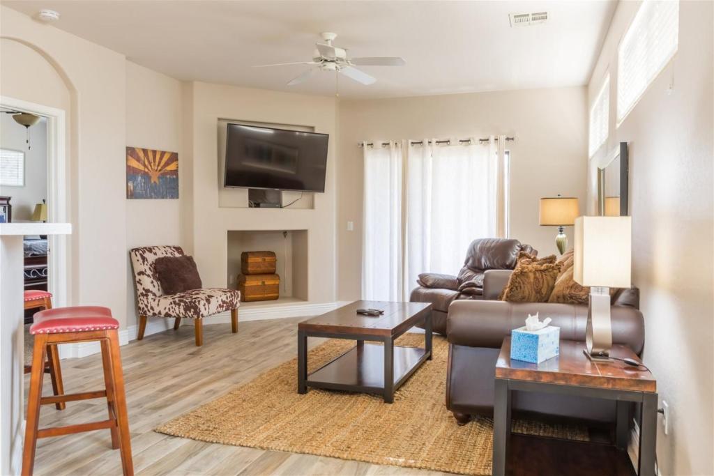 a living room with a couch and a tv at Gated Ocotillo Townhouse with heated pool, spa, BBQ in Chandler