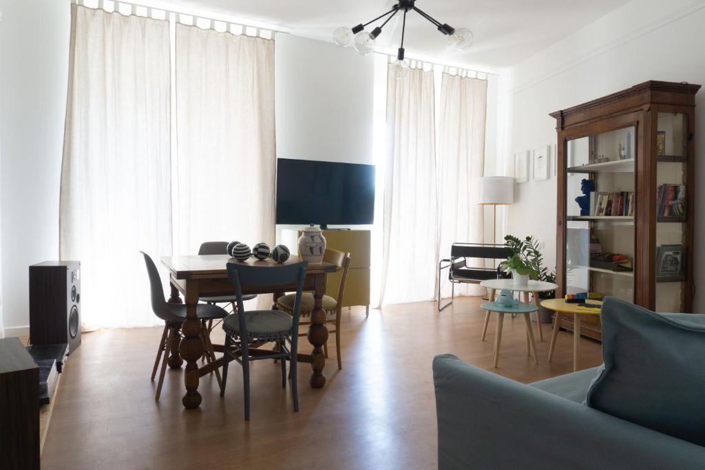 een woonkamer met een tafel en stoelen en een bank bij Appartamento Camillo in Macerata