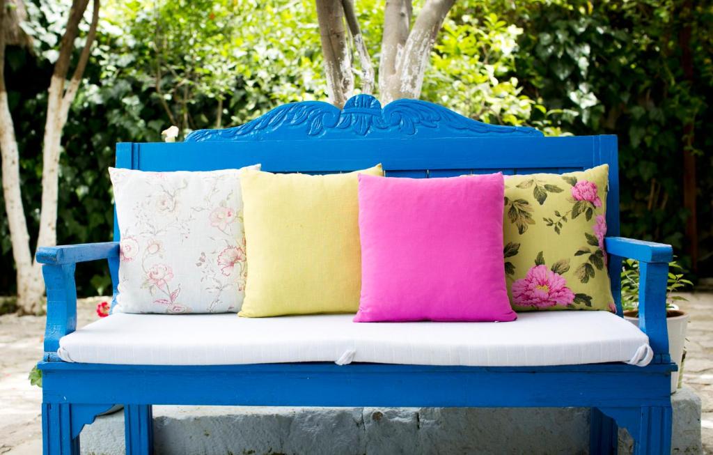 a blue bench with colorful pillows on it at Morlimon in Alaçatı