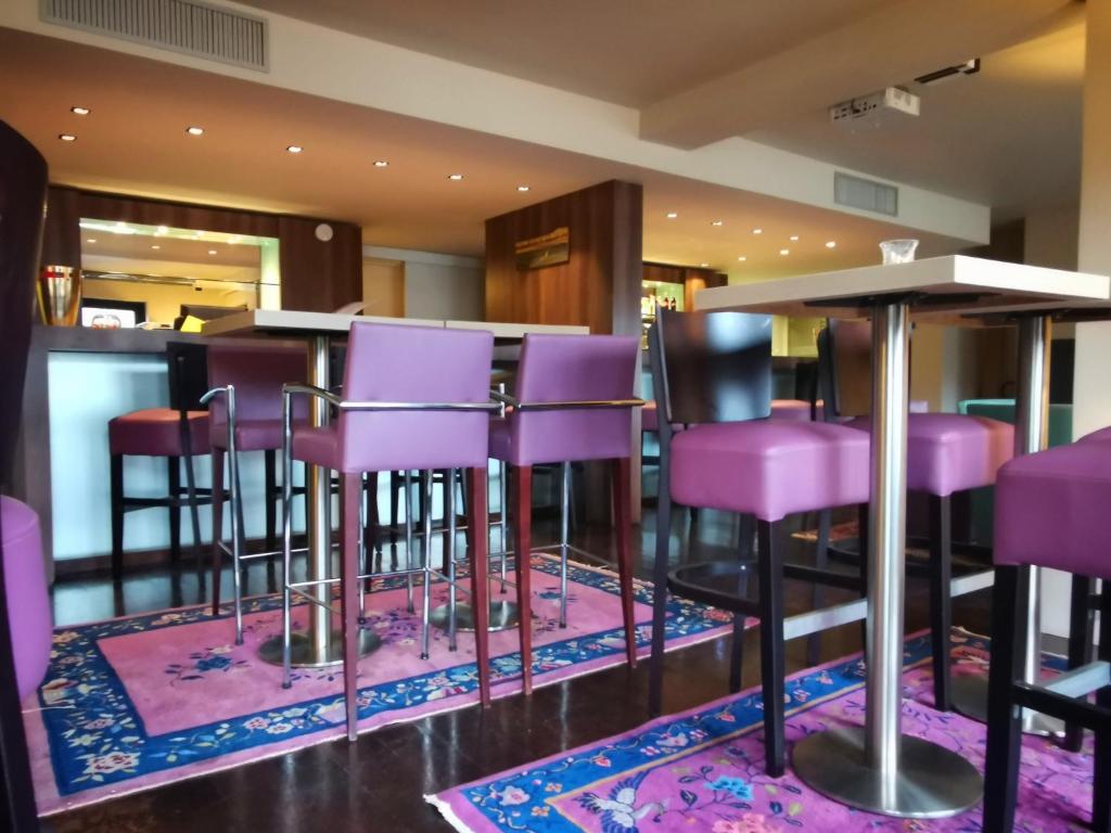 eine Bar mit lila Barhockern in einem Restaurant in der Unterkunft Hotel du Casino in Saint-Valéry-en-Caux