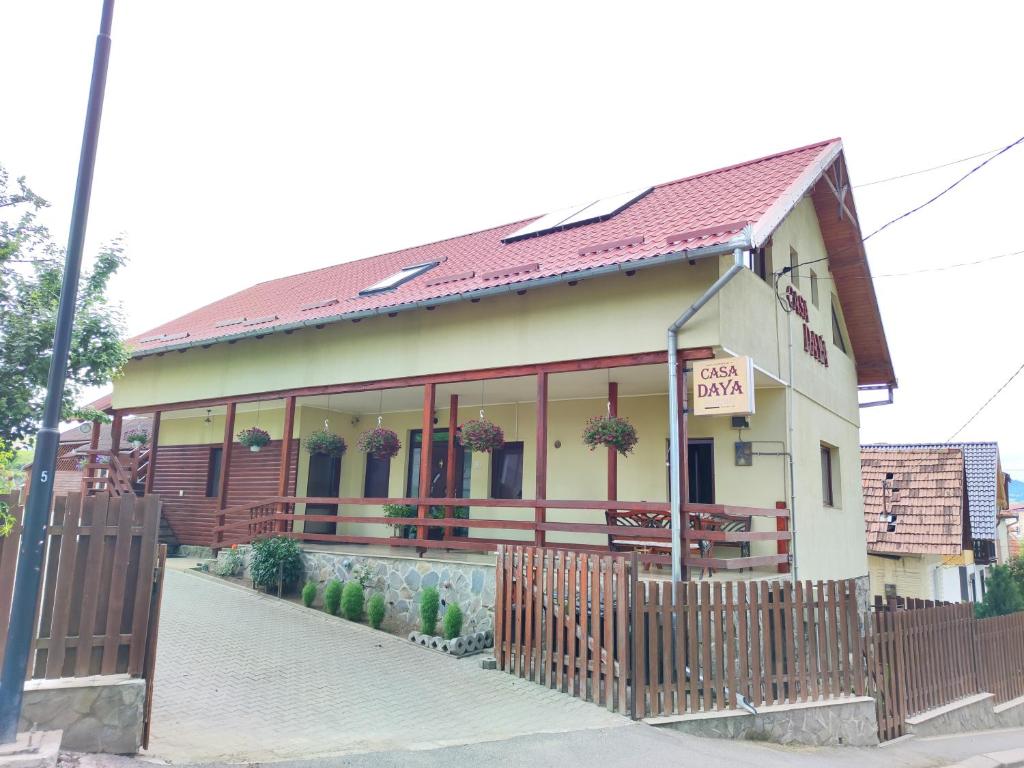a building with a fence in front of it at Casa Daya in Topliţa
