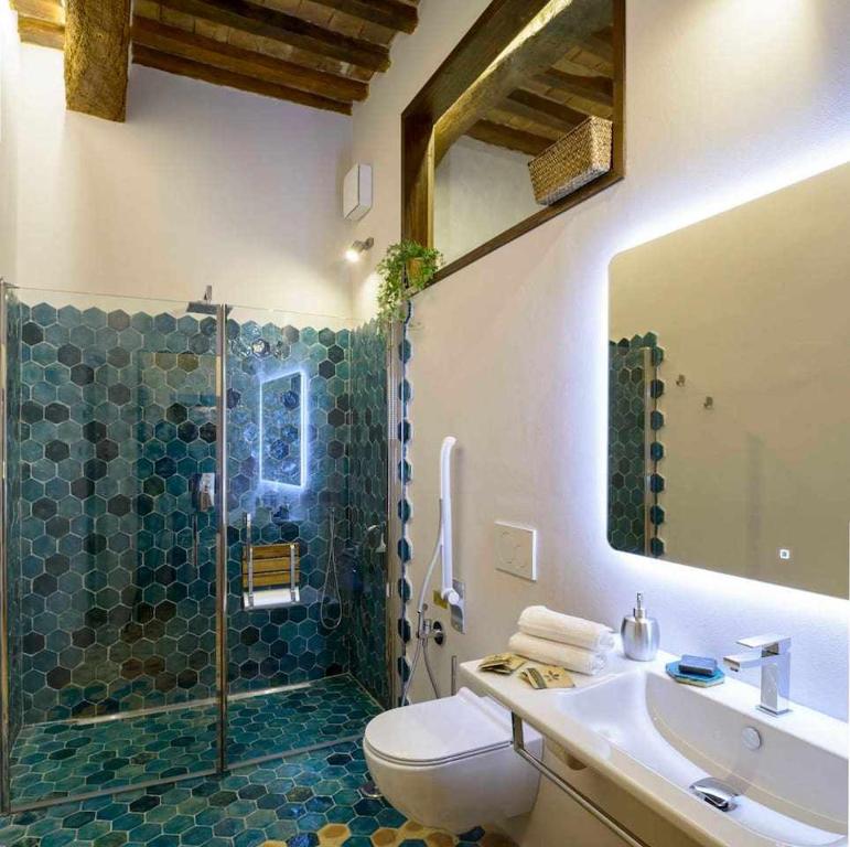 La salle de bains est pourvue de toilettes, d'un lavabo et d'une douche. dans l'établissement Domus Calzolari, à Gubbio