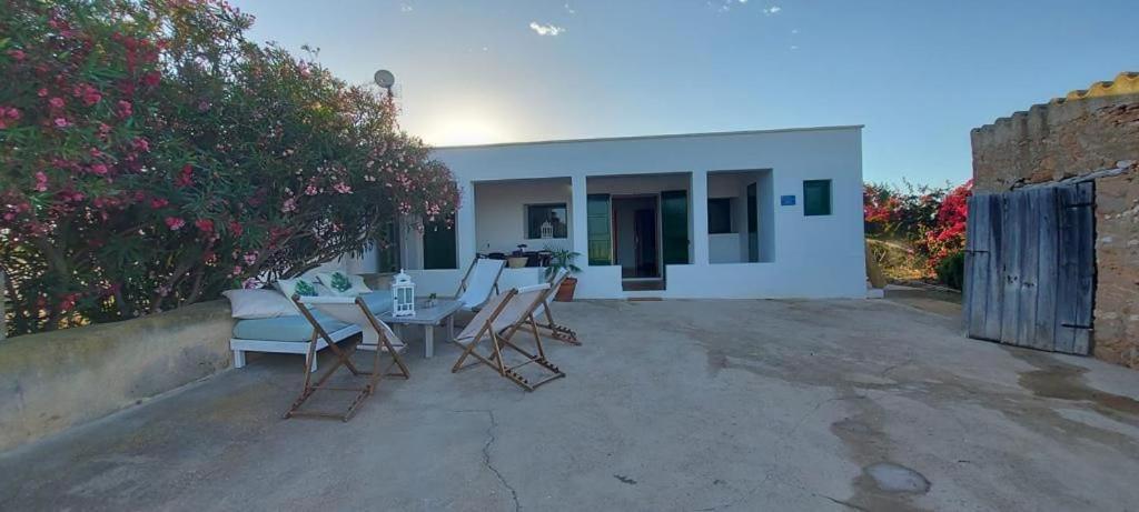 un patio con sedie e tavolo di fronte a una casa di Viviendas Ferrer - Can Joan Andrauet a Sant Francesc Xavier